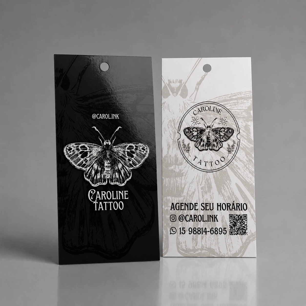 Tag personalizada para estúdio de tatuagem Caroline Tattoo em preto e branco, com ilustração detalhada de mariposa, QR code de agendamento e informações de contato.