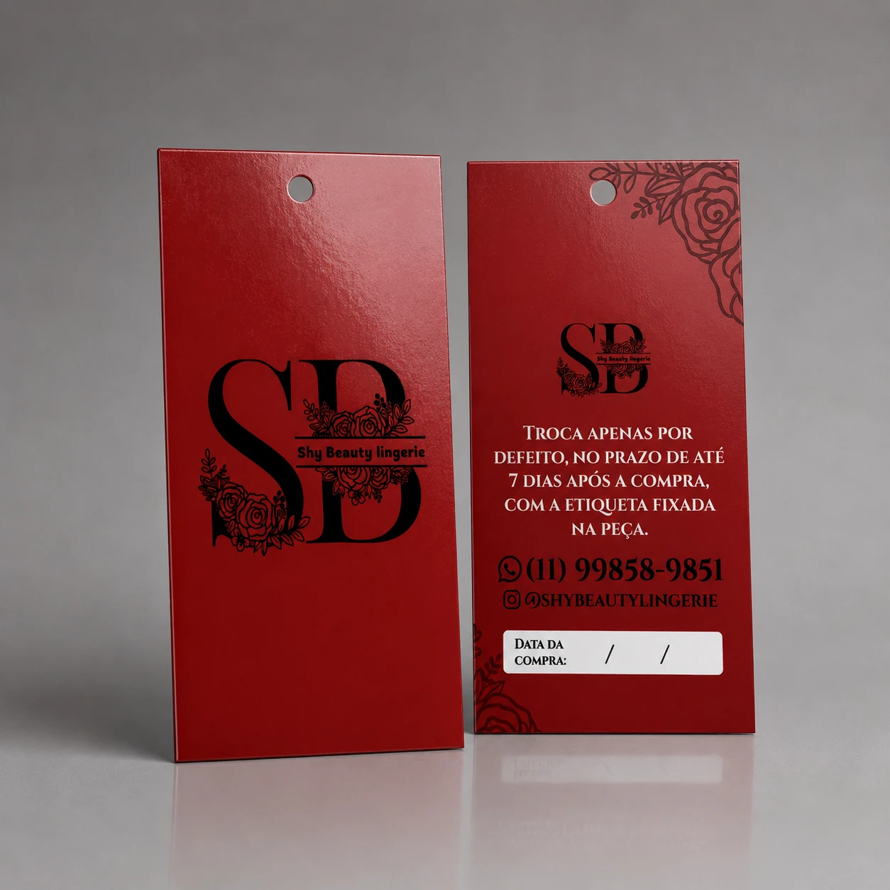 Tag de papel vermelha para marca Shy Beauty Lingerie com monograma SB decorado com rosas pretas, política de troca e espaço para data da compra.